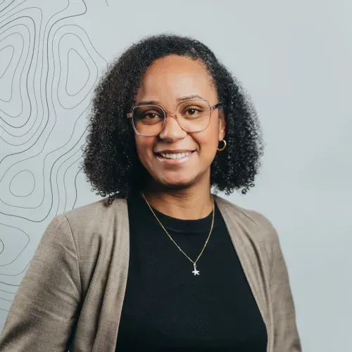 Portrait of Karina Paul, Novaterra Sales and Leasing Executive, smiling in glasses, a black top and beige blazer