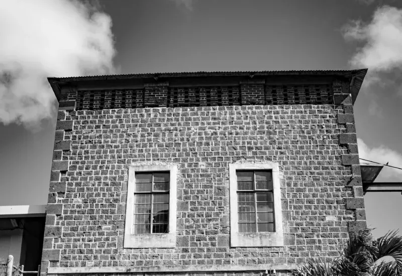 Black and white view of the 1929 pavilion, a former rum distillery in basalt stone with two windows, Beau Plan Business Park