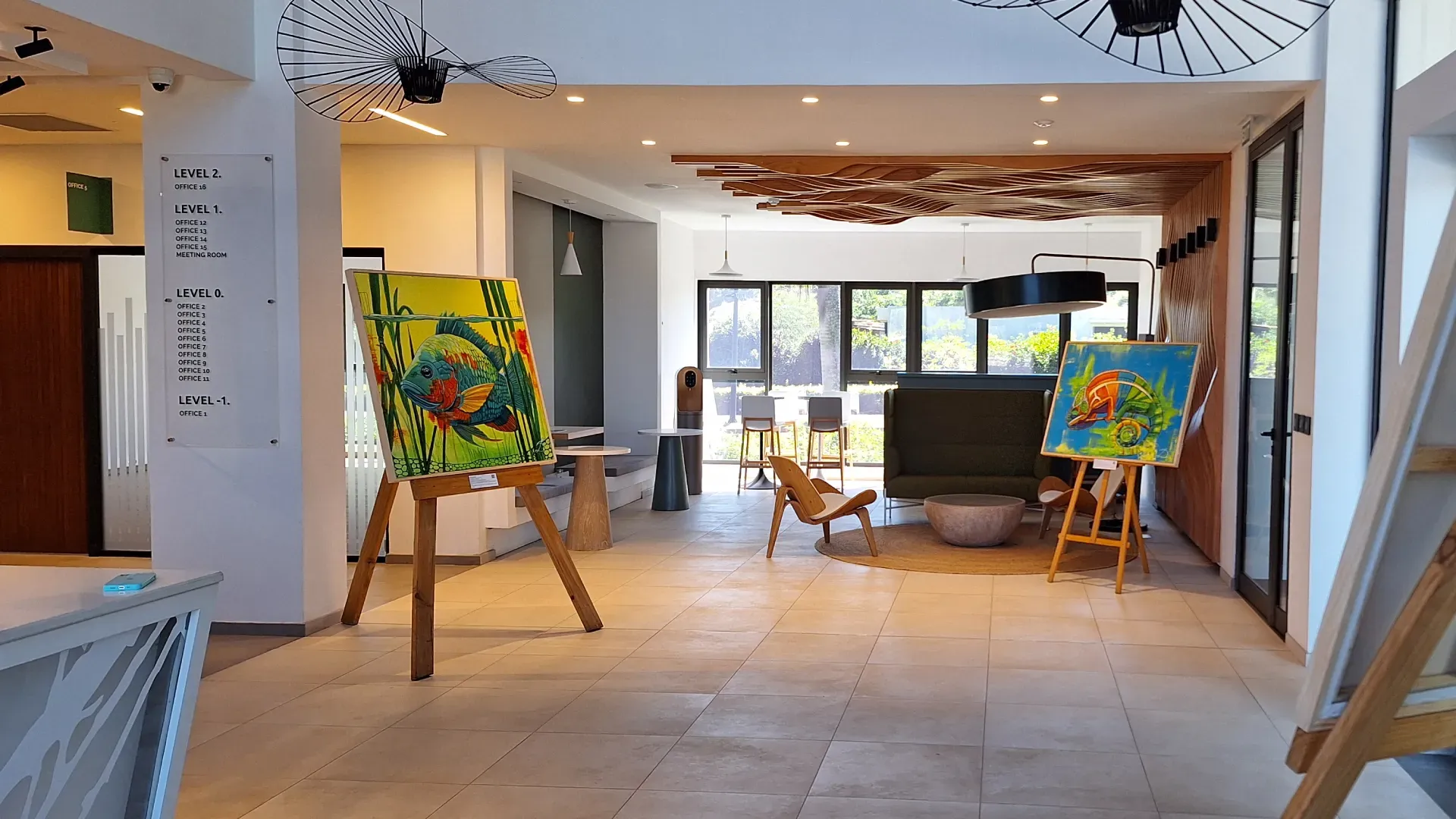 Lobby of The Strand office building in Beau Plan with colourful fish paintings on easels, floor directory and lounge seating