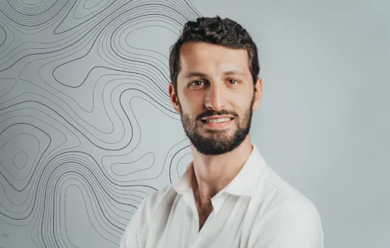 Romain Espitalier Noel, Sales and Leasing Consultant at Novaterra, smiling in a white shirt against a contour-line backdrop