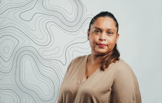 Portrait of Angeni Balgobin, Land Survey Technician, in front of a wall with topographic contour lines