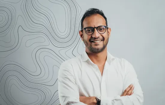 Shadil Golam Hossen, Sales & Leasing Executive, smiling with arms crossed in a white shirt before a contour-line wall