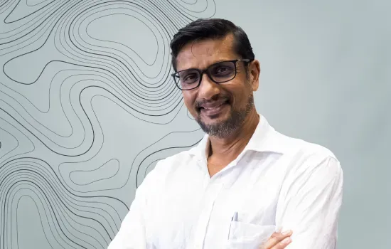 Ashwin Rampersand, Senior Manager – Projects & Implementation, smiling with arms crossed in a white shirt and glasses