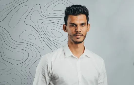 Vimal Ramjug, Development Manager at Novaterra, in a white shirt before a wall with topographic contour lines