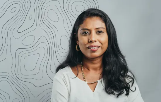Portrait of Prema Caussy Mooken, Manager - Projects & Implementation, smiling before a topographic line pattern