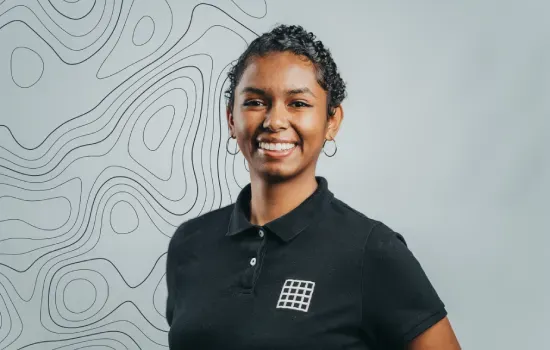 Theresa Marouvenne, Novaterra Property Administrator, smiling in a black logo polo shirt against a topographic-line backdrop