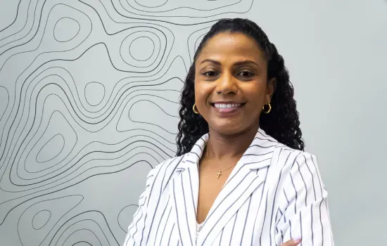 Lucile Momple, Syndic Manager at Novaterra, smiling in a white striped blazer before a contour-line wall