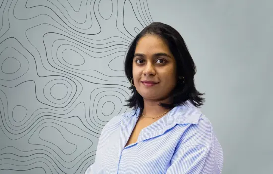 Navina Poinen, Accountant at Novaterra, in a striped blue shirt against a grey wall with topographic contour lines
